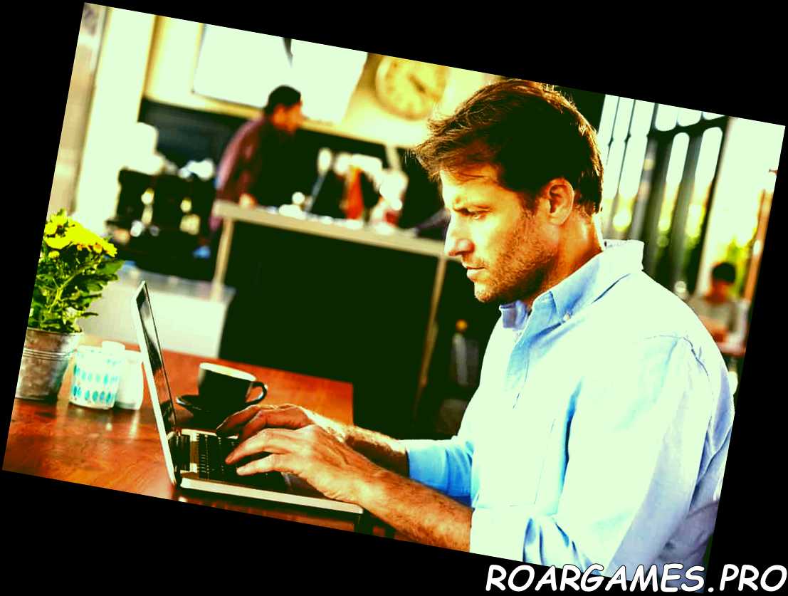 Hombre trabajando con un portátil en una cafetería. 