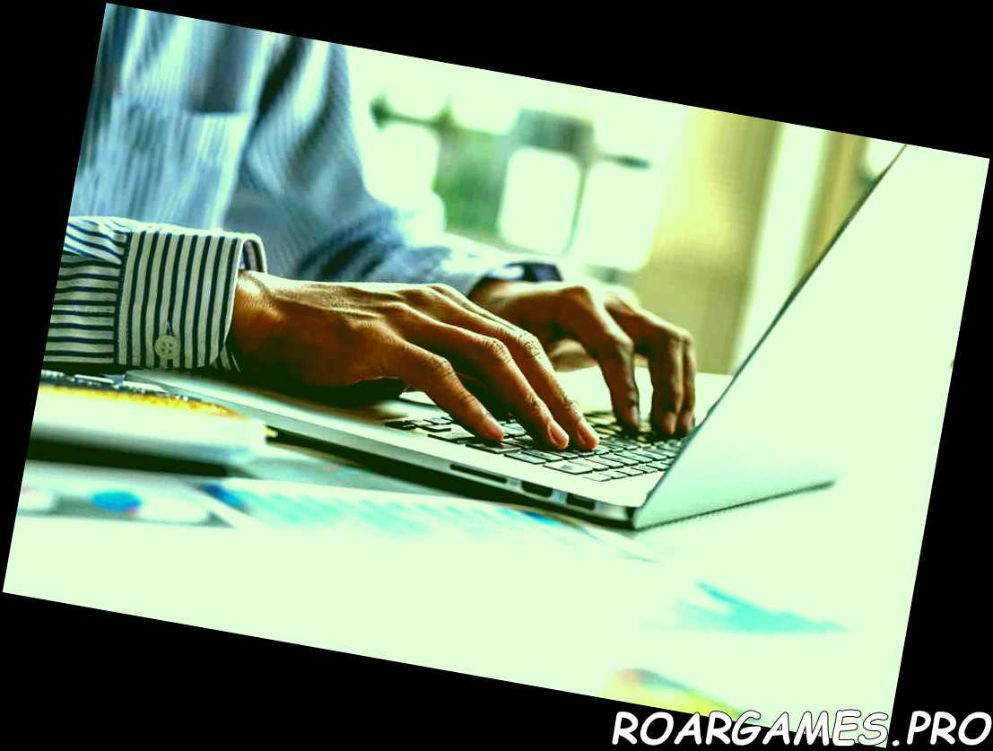 Cerrar la mano del empresario escribiendo en el teclado de un ordenador portátil en la oficina