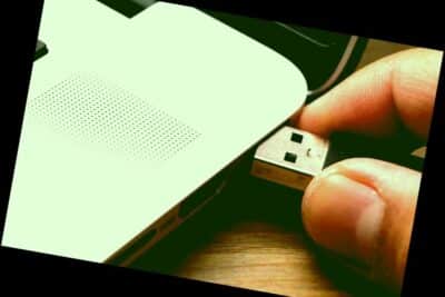 Detalles de la mano empujando el cable USB en la ranura USB de la computadora portátil