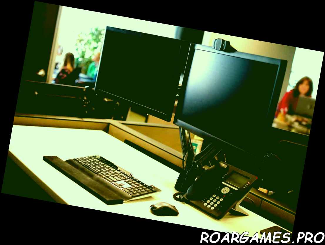 Computadora con dos monitores y teléfono en el escritorio