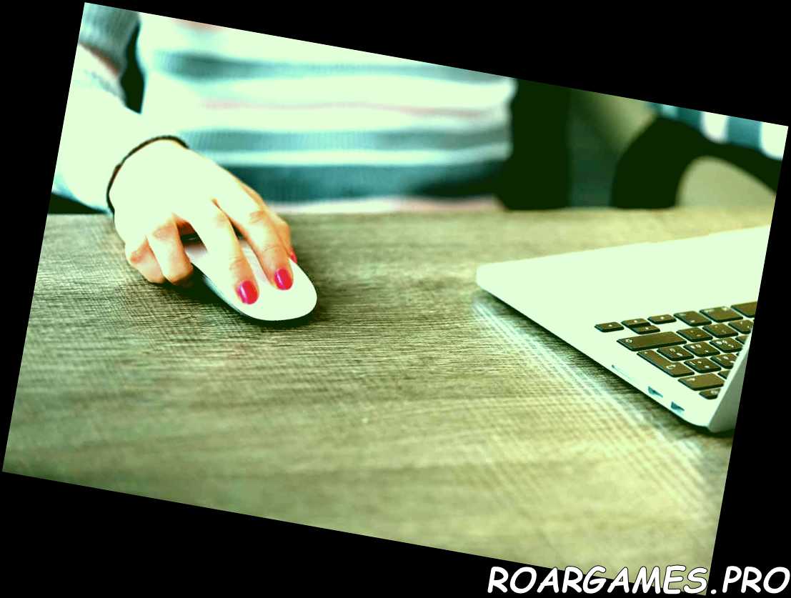 Ratón de computadora de mano femenina frente a la computadora portátil