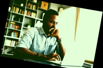 Centrado concentrado joven empresario africano sentarse en el escritorio mirar portátil