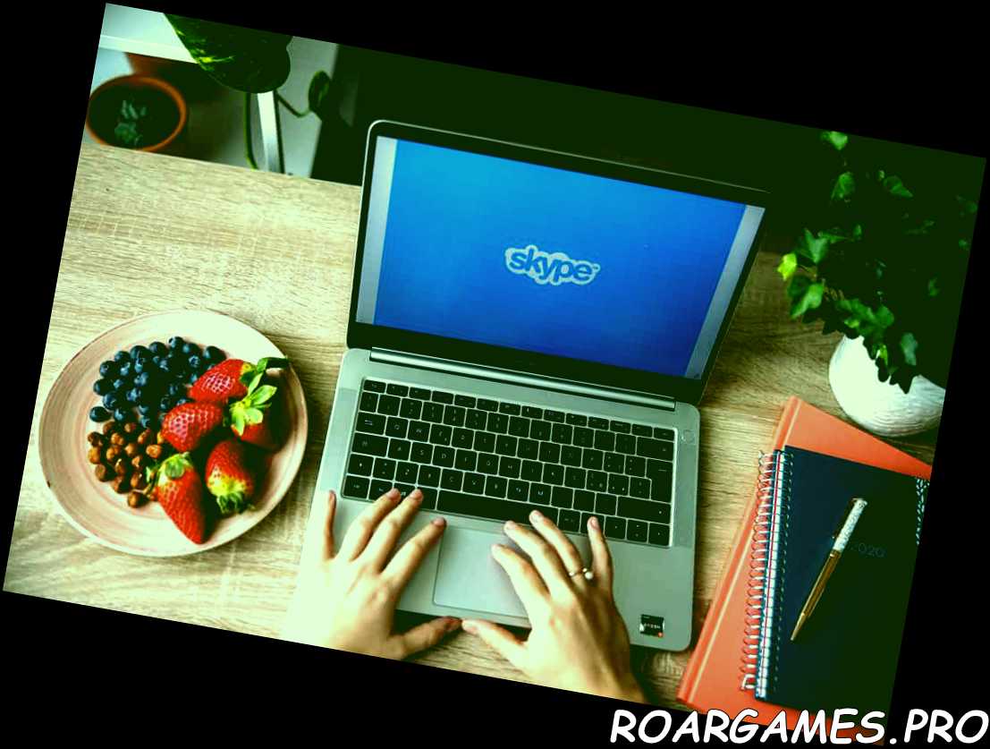 Chica que trabaja charlando remotamente en Skype con su computadora portátil y un plato de fruta fresca