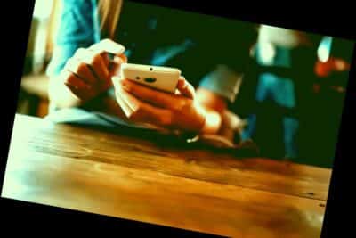 usando el teléfono inteligente en la mesa de madera